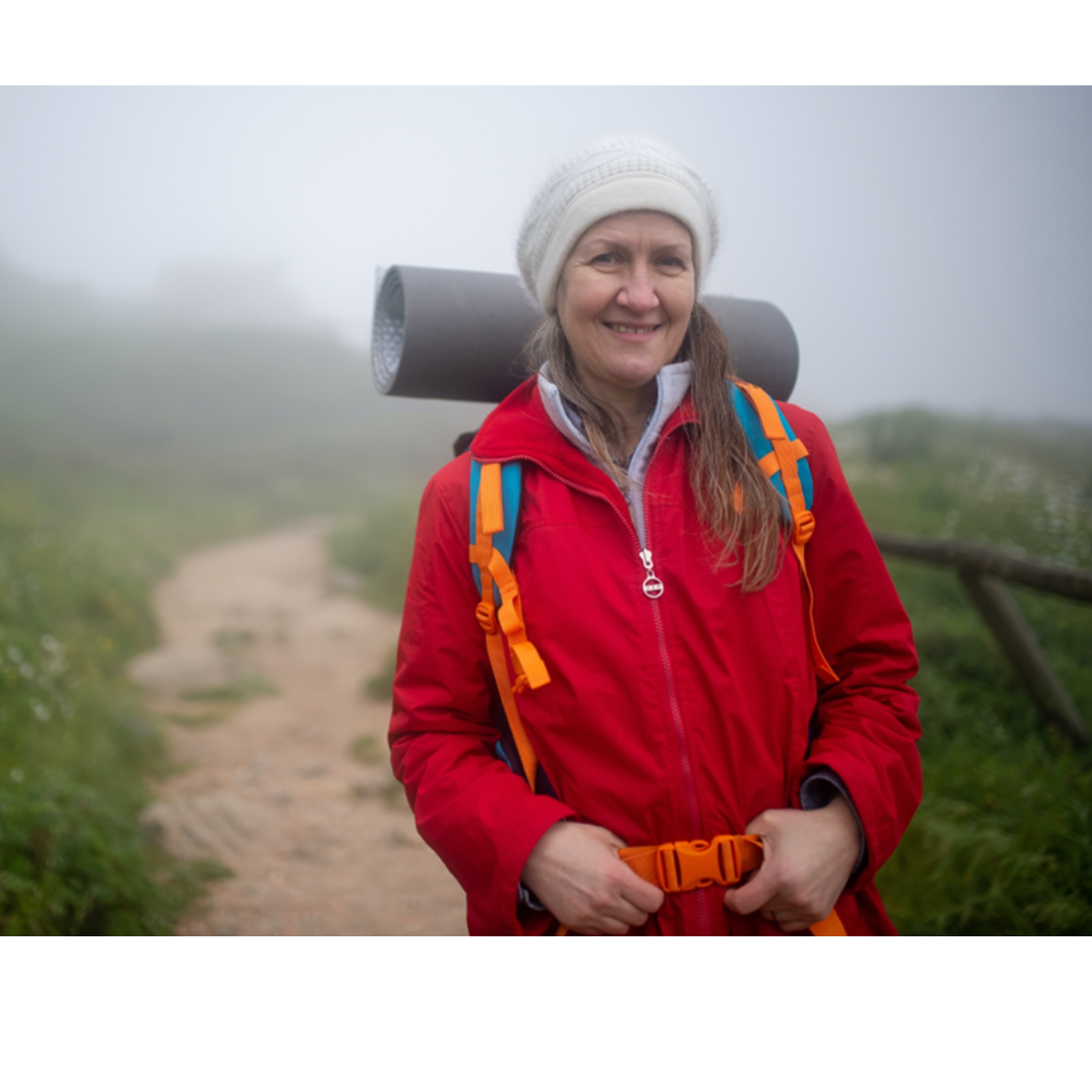 Older Lady backpacking in an open field